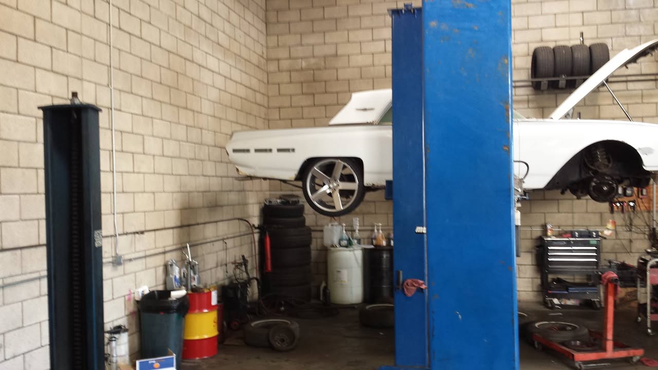 Inside General Auto Service, a classic car up on the lift